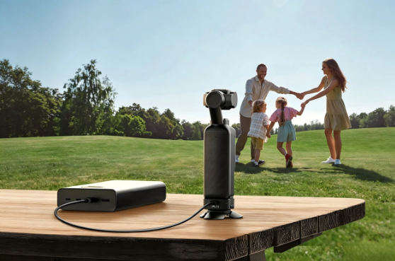Ulanzi Mini Tripod setup with DJI Pocket 4 mounted on a compact stabilizer placed on a wooden outdoor table with a power bank, showing a family park background for lifestyle filming.