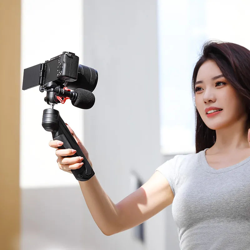 Woman holding Ulanzi TT38 tripod with camera and mic, ideal for vlogging and content creation.