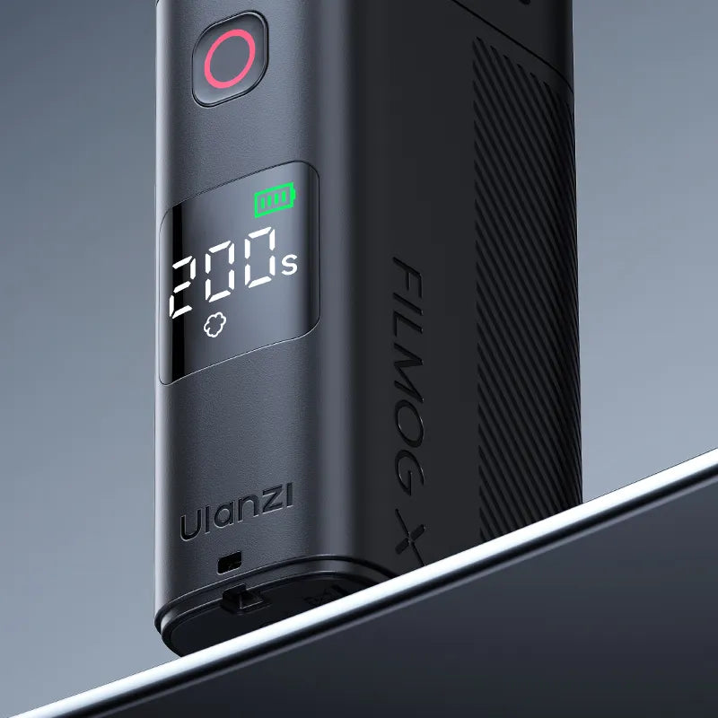 A portable fog machine displaying a timer and battery status, placed on a reflective surface.