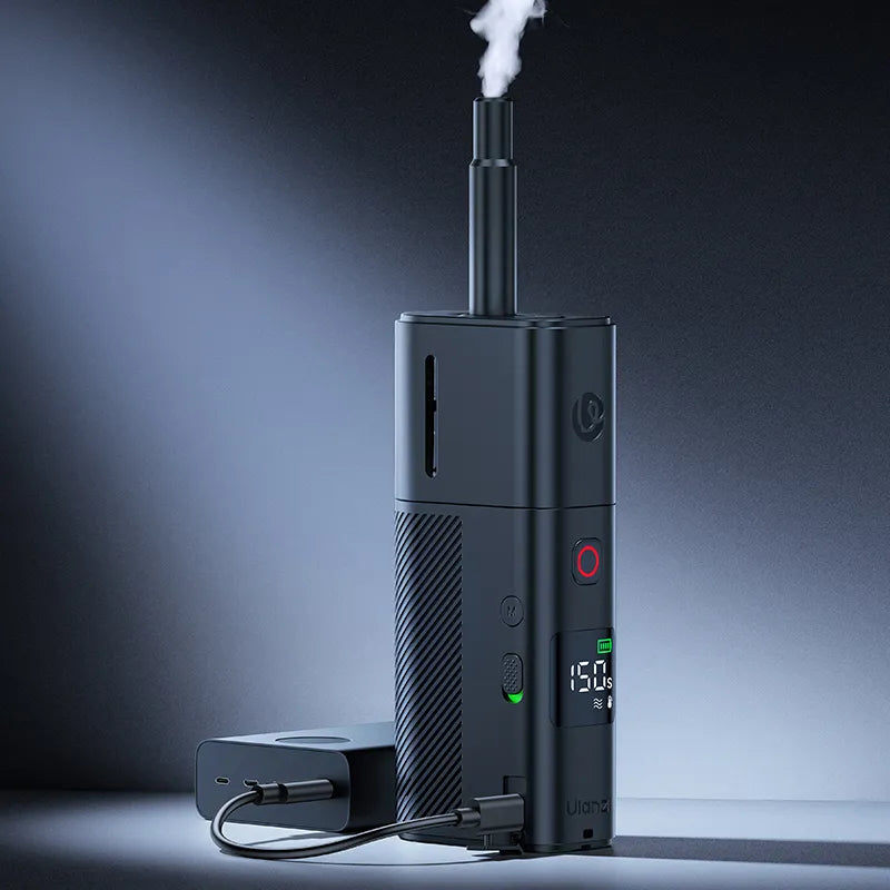 A portable Ulanzi fog machine emitting fog while connected to a power source on a smooth surface.