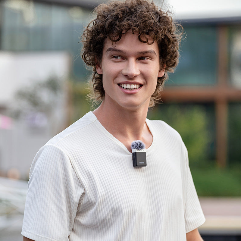 Ulanzi U-Mic Wireless Lavalier Microphone System used by a smiling man outdoors, capturing audio.