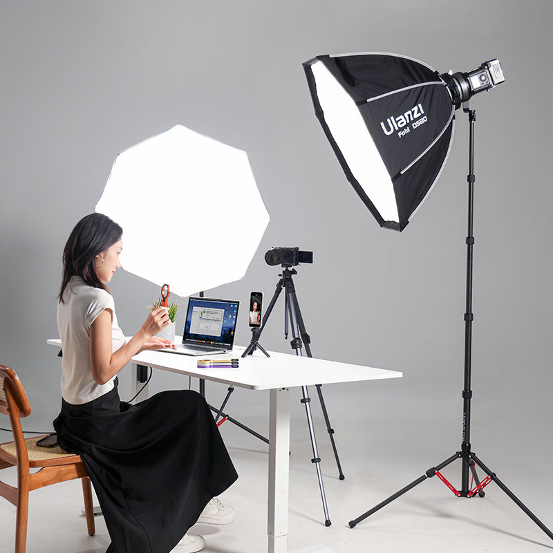 Woman working at desk with Ulanzi T230 light stand and softbox.