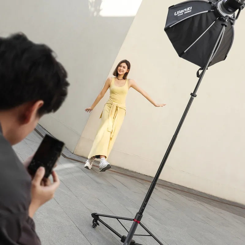 Ulanzi AT-05 light stand supporting softbox during outdoor photoshoot with model.