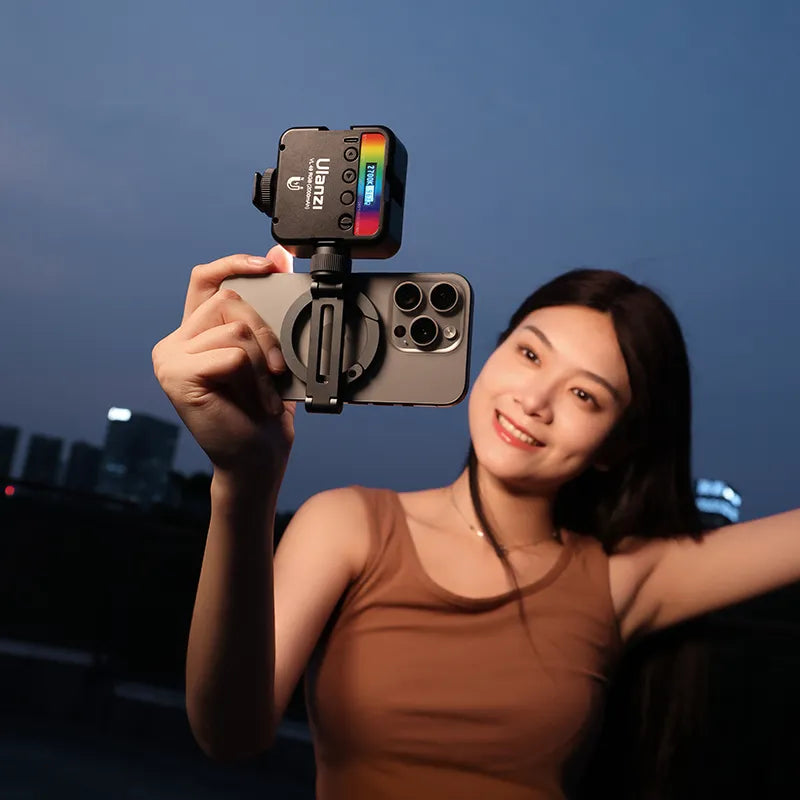 Woman holding Ulanzi MA07 Maglock phone mount with light attached, outdoor content creation setup.