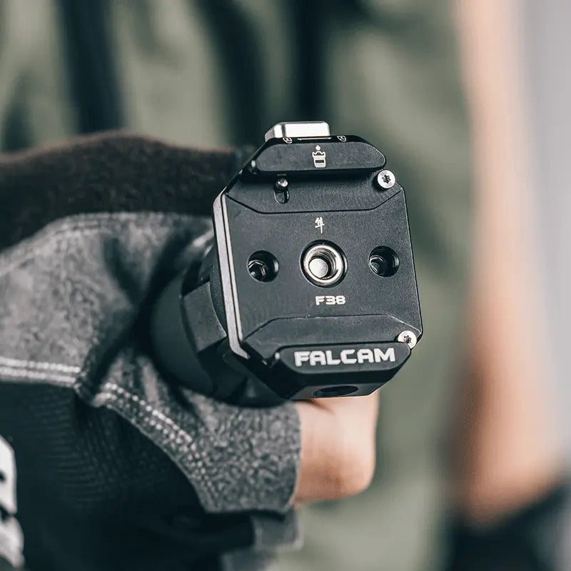Ulanzi Falcam F38 Multi-hole Quick Release Base in hand, black aluminum alloy, F38 model.