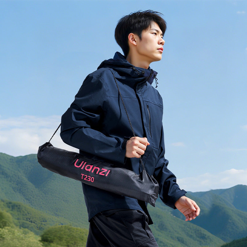 Man carrying Ulanzi T230 light stand in bag outdoors.