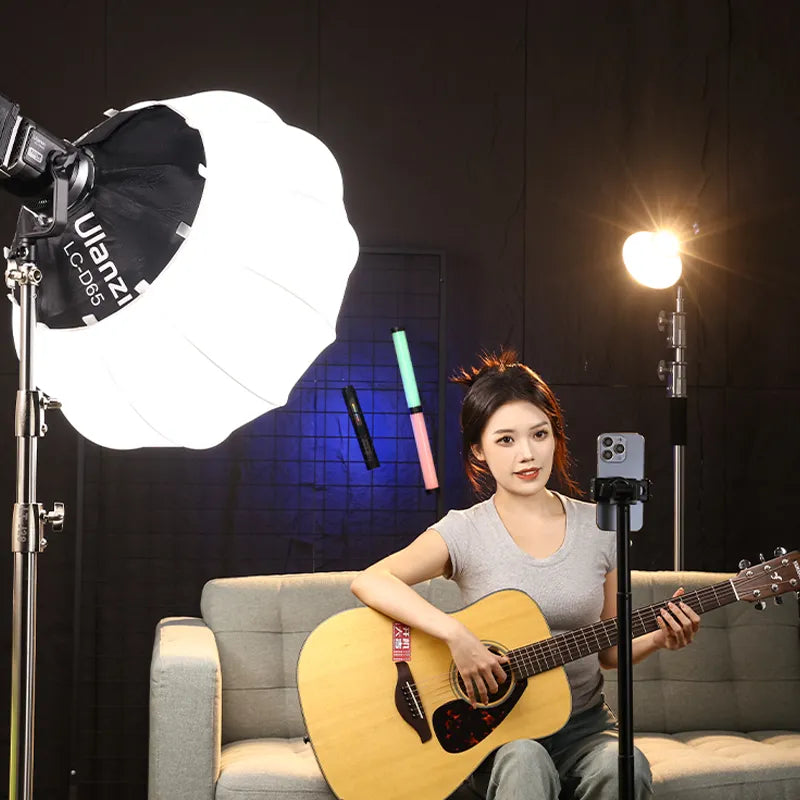 Woman using Ulanzi LC-D65 softbox and video light for beauty or music video production.
