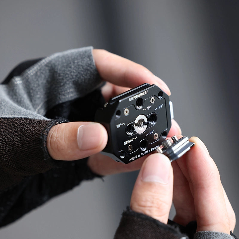 Falcam F38 Multi-hole Quick Release Kit in hand, black aluminum alloy base with threads, FALCAM.