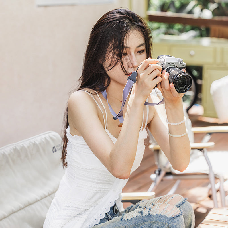 Woman using Ulanzi Falcam Maglink Lite Shoulder Strap with FUJIFILM X-T4 camera, light gray strap.