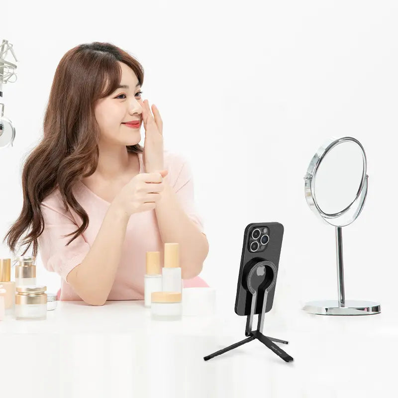 Woman using Ulanzi MA29 MagSafe Phone Stand for beauty tutorial, foldable and compact design.