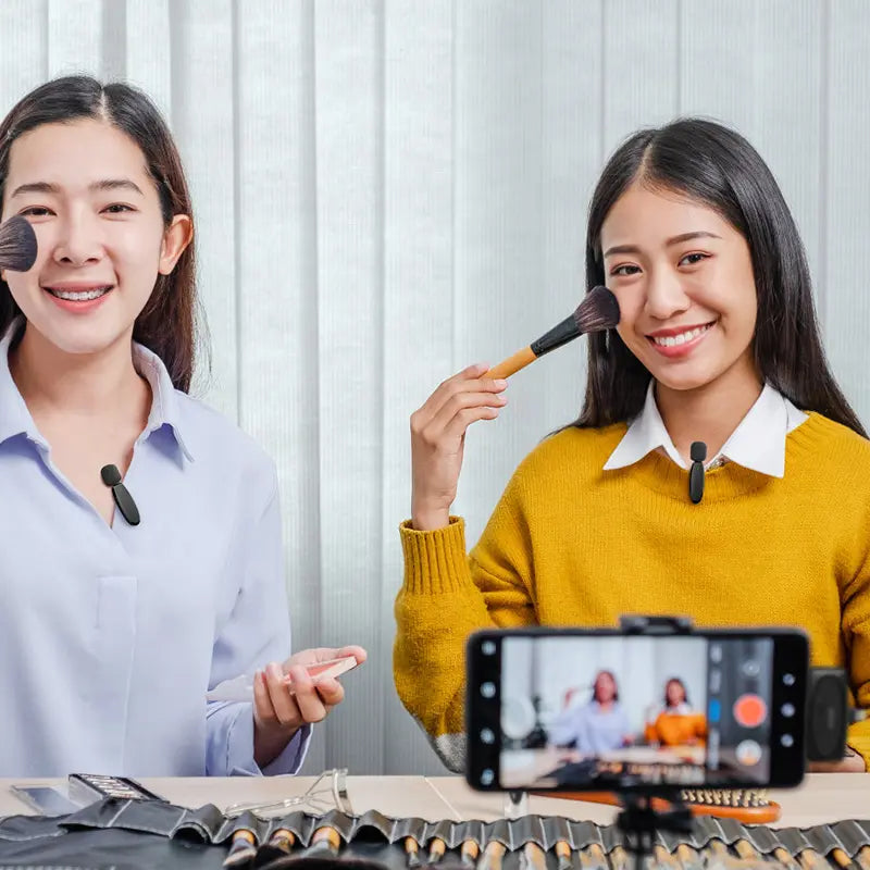 Two women with Ulanzi V6 wireless lavalier microphones applying makeup and recording video.
