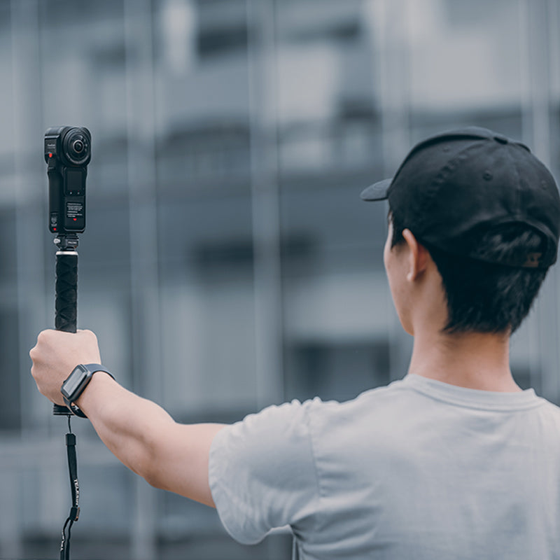 Man holding Insta360 action camera with F22 Quick Release Kit, perfect for 360° shots.