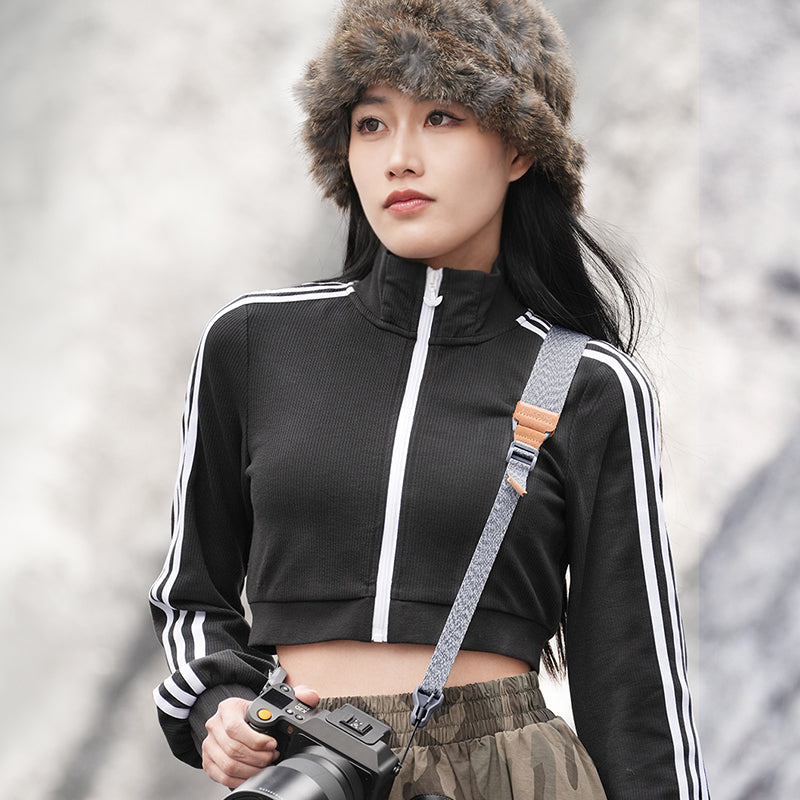 Ulanzi Falcam Maglink shoulder strap in use. Woman with camera, grey strap with magnetic buckle.
