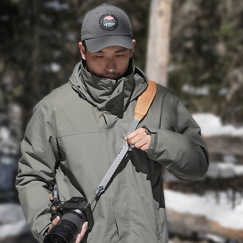 Ulanzi Falcam Maglink Pro shoulder strap on a man holding camera, dark gray strap.