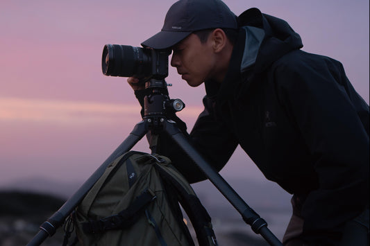 Photographer using tripod at sunset.