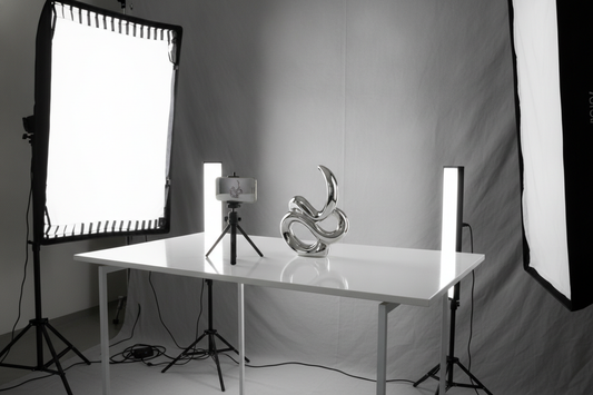 Reflective product video setup with a phone, bright light, and glossy item on a tabletop