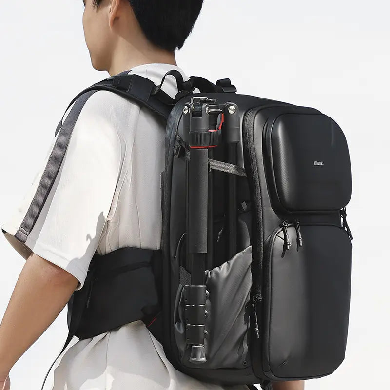 Person carrying a black camera backpack with Ulanzi monopod tripod attached.