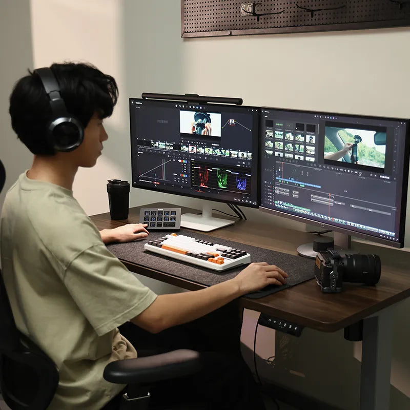 Content creator editing videos with Ulanzi Stream Controller D200 and dual monitors.