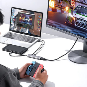 User playing Nintendo Switch with Ulanzi C060 video capture card connecting to laptop