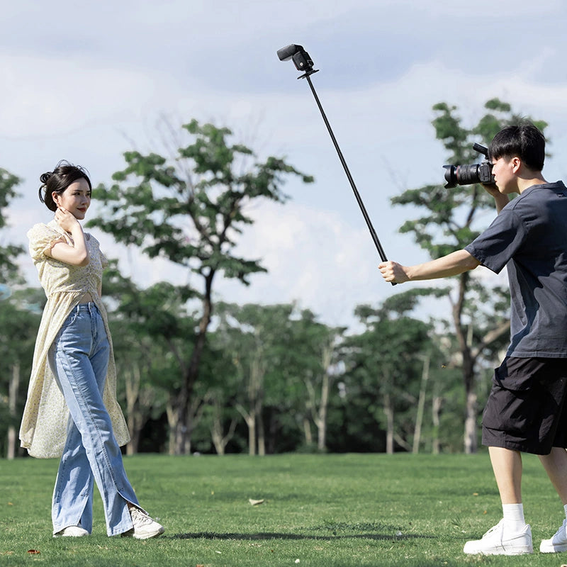 User holding Ulanzi selfie stick pole for photography outdoors in park.