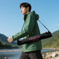 A man walking outdoors, carrying an Ulanzi MT-80 tripod.