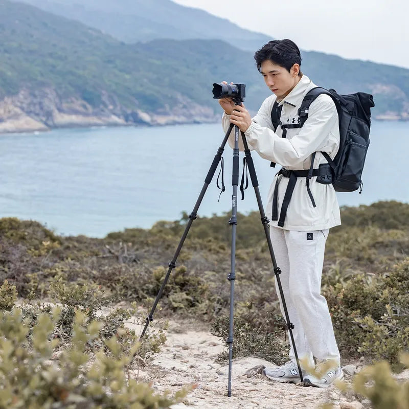 Photographer using Ulanzi TT35 Tripod Kit on a hiking trail near the coast.