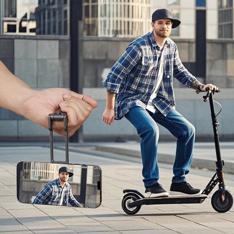 Man riding an electric scooter with a smartphone showing a reflection of him