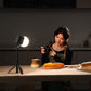 Food photographer capturing artisanal bread with soft round LED light creating intimate kitchen atmosphere.