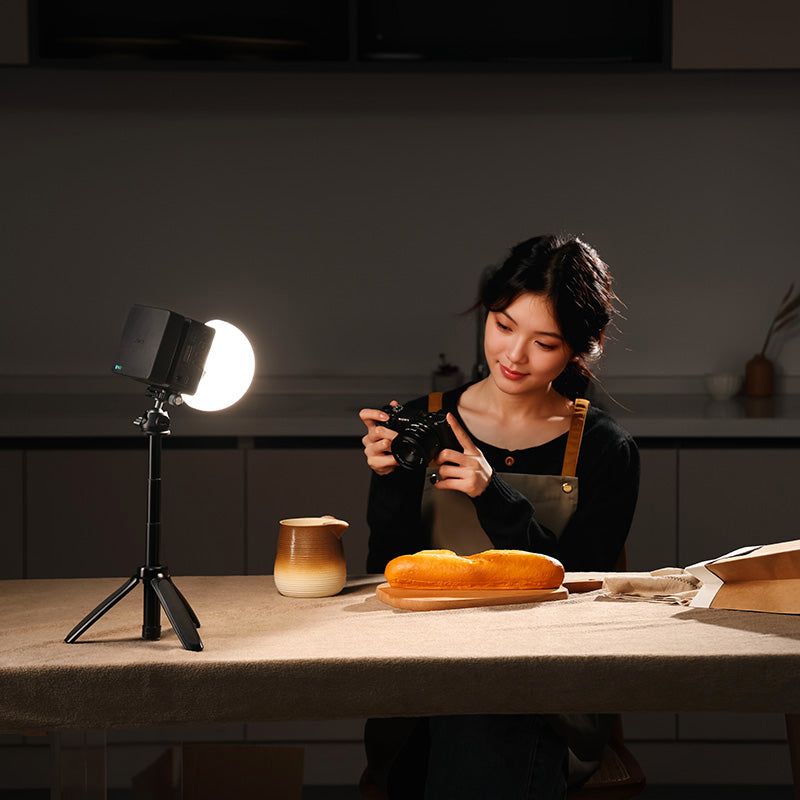 Food photographer capturing artisanal bread with soft round LED light creating intimate kitchen atmosphere.
