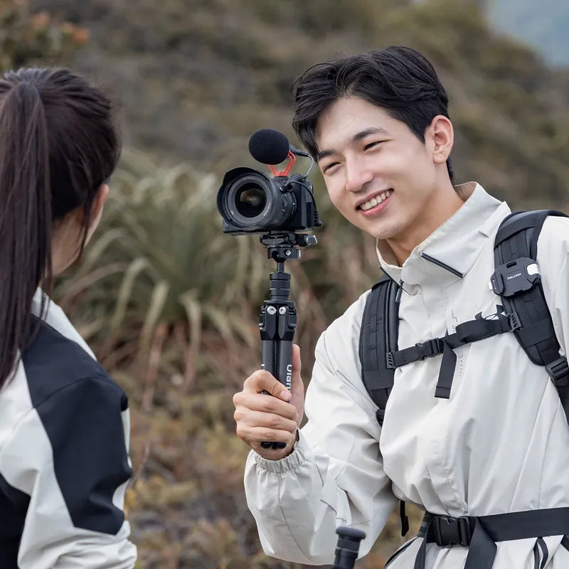 Photographer using Ulanzi TT35 Tripod Kit with camera outdoors.