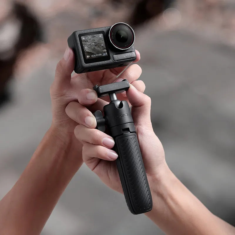 Hands holding an Ulanzi MT66 tripod with an action camera mounted, showcasing its compact size and compatibility.