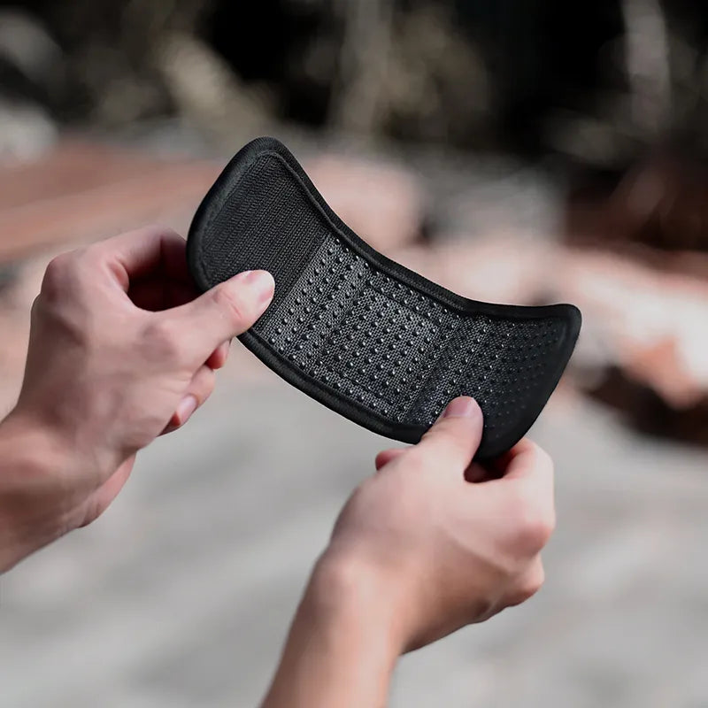 Close-up of a hand holding the flexible, anti-slip shoulder strap pad for the Ulanzi MT66 tripod, highlighting its textured grip.