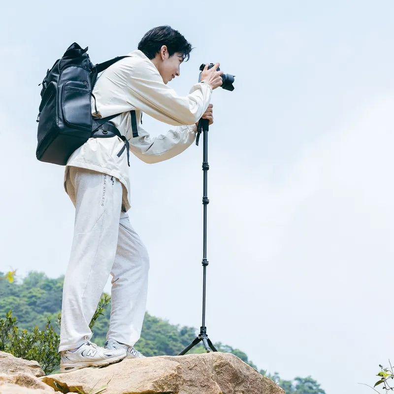Photographer using Ulanzi TT35 Tripod Kit on rocky terrain for stability.