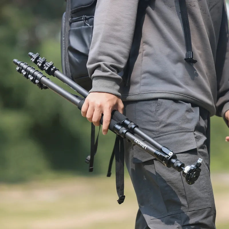 Person holding Ulanzi TT35 Tripod Kit while hiking outdoors.