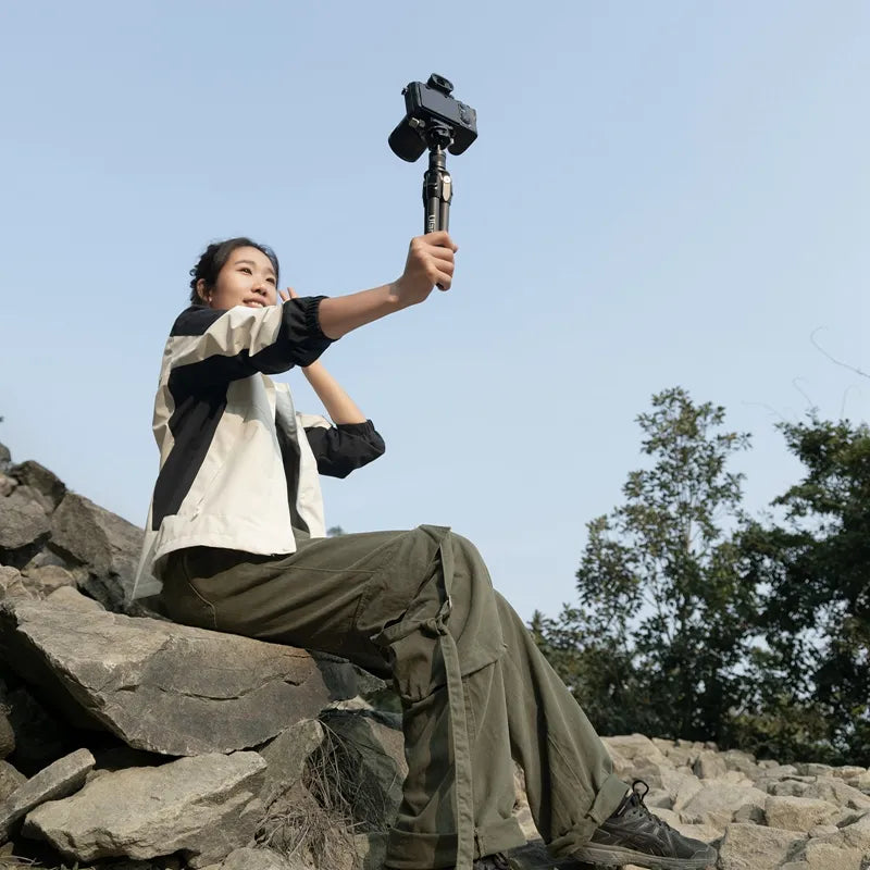 User holding Ulanzi TT35 Tripod Kit for photography on rocky terrain.