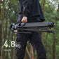 Person carrying Ulanzi VideoFast Heavy Duty Tripod Kit in a forest setting.