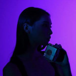 Woman holding Ulanzi LE20 20W Pocket RGB Video Light, product shot with stylish purple backdrop.