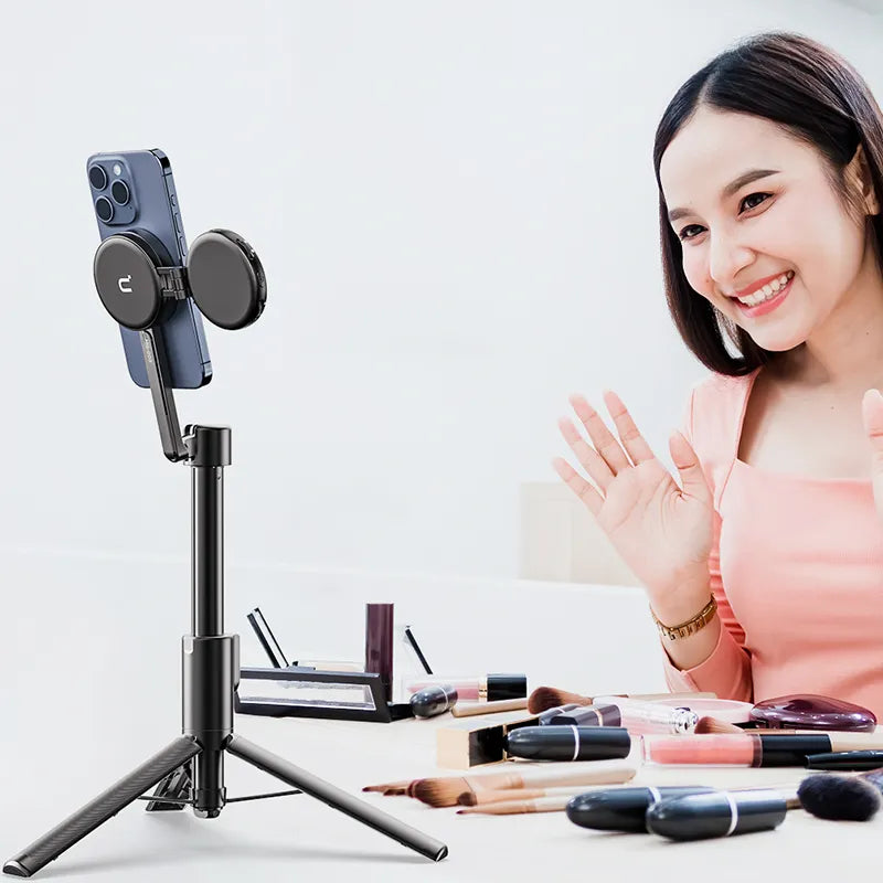Woman using Ulanzi MG-003 selfie stick tripod for video call while applying makeup
