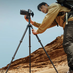 Photographer using TreeRoot Quick Lock Lite Tripod in a desert landscape.