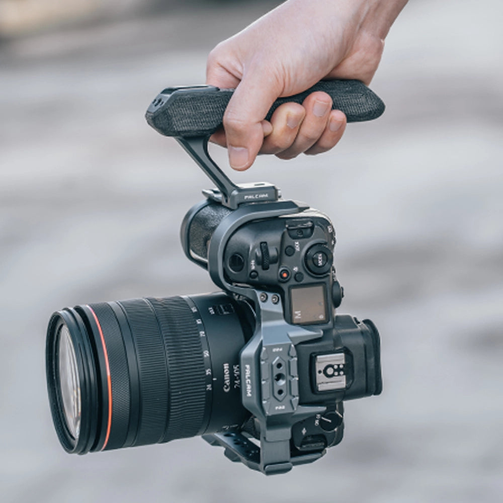 Hand holding Ulanzi F22 Quick Release top handle attached to a camera