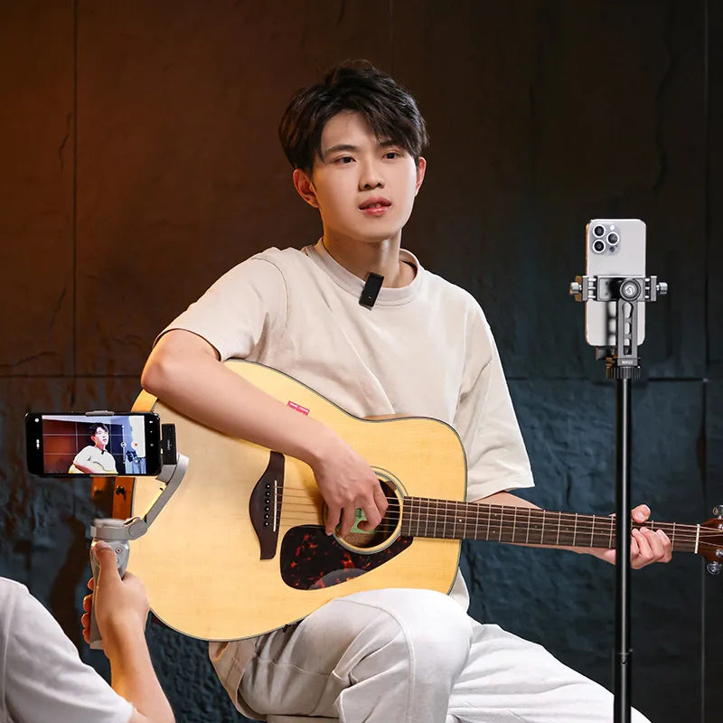 Person playing guitar and singing with Ulanzi HM2301 microphone and smartphones.