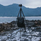 Ulanzi travel tripod with camera and backpack on rocky shore near water