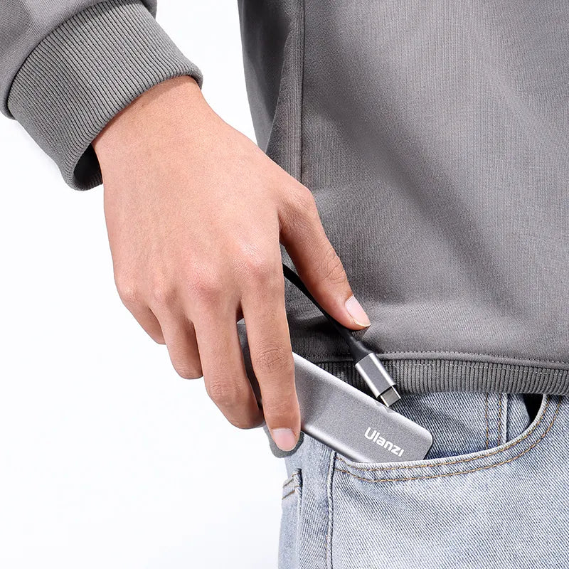 Person placing Ulanzi C060 USB-C video capture card into pocket.