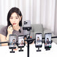 Woman applying lipstick while recording with multiple smartphones on a rig