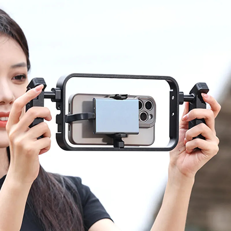 Smartphone secured in camera rig held by woman for filming.