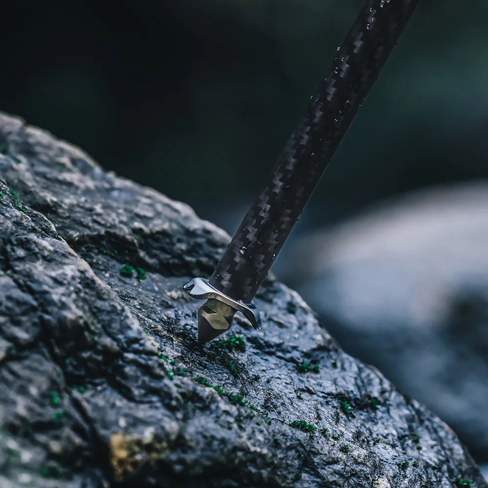 Ulanzi carbon fiber tripod leg anchored on rocky terrain for stability.
