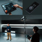 A studio setup with a professional light, a tablet displaying a lighting control interface, and a remote control device for adjustments.
