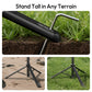 A tripod leg being anchored into the ground with a metal stake.
