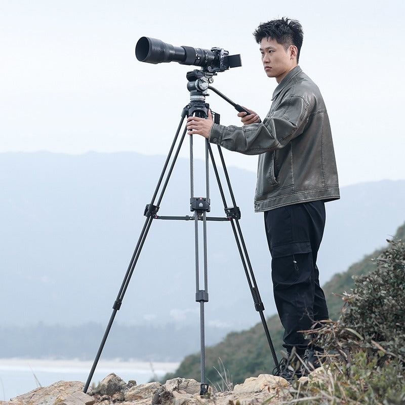 User operating Ulanzi VideoFast Heavy Duty Tripod with large camera outdoors.