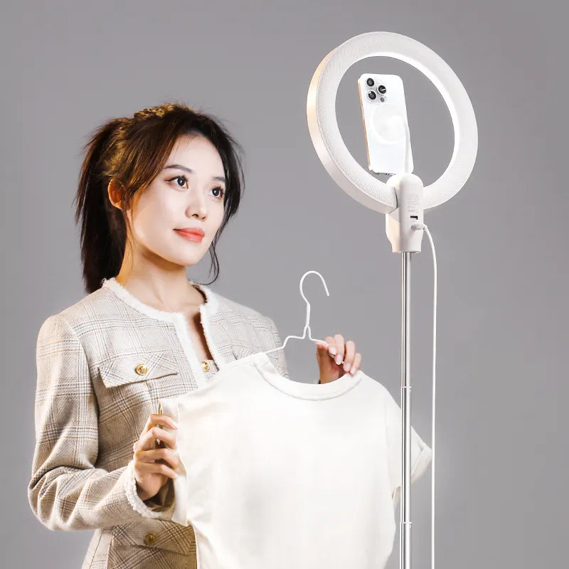 Woman showcasing a t-shirt under 10-inch LED ring light with phone holder.